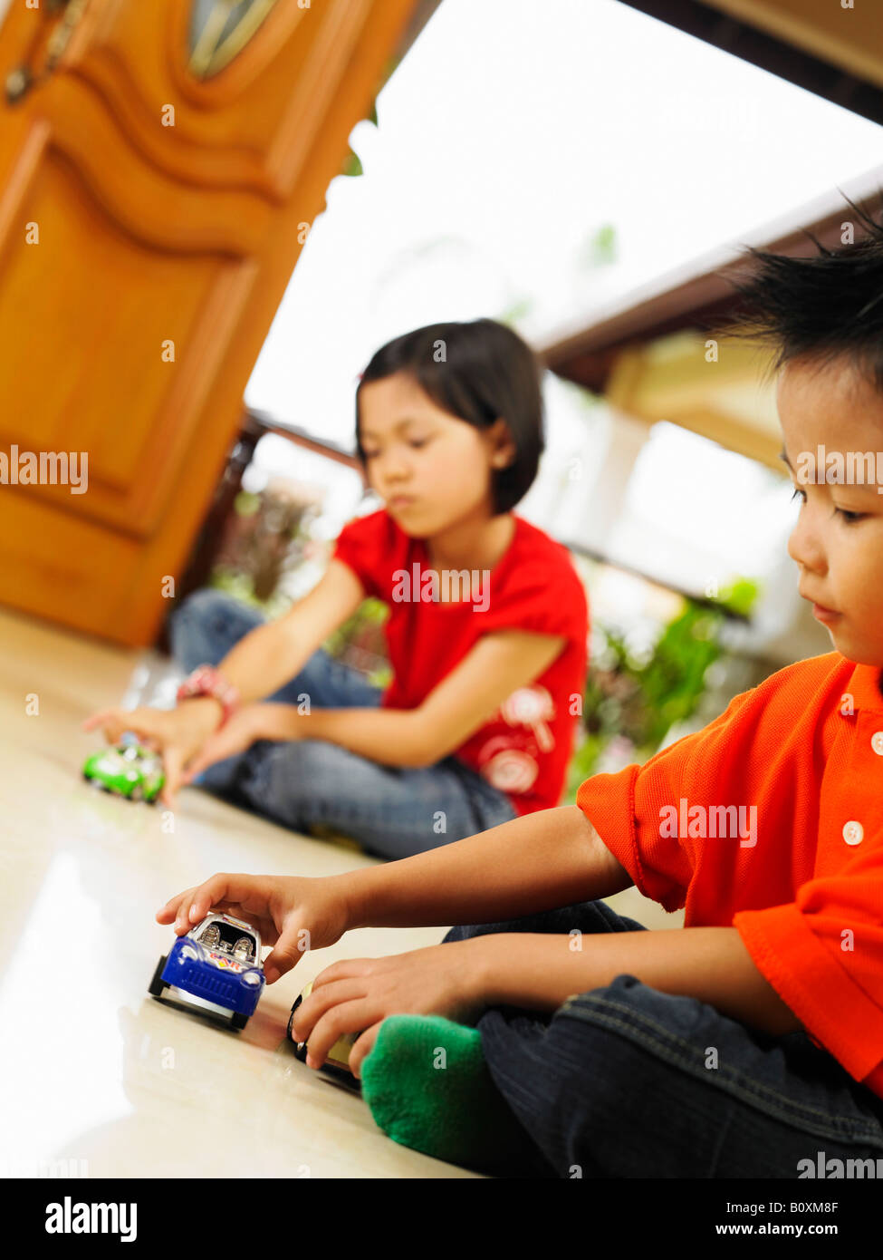 Sister and brother playing toy car together Stock Photo - Alamy