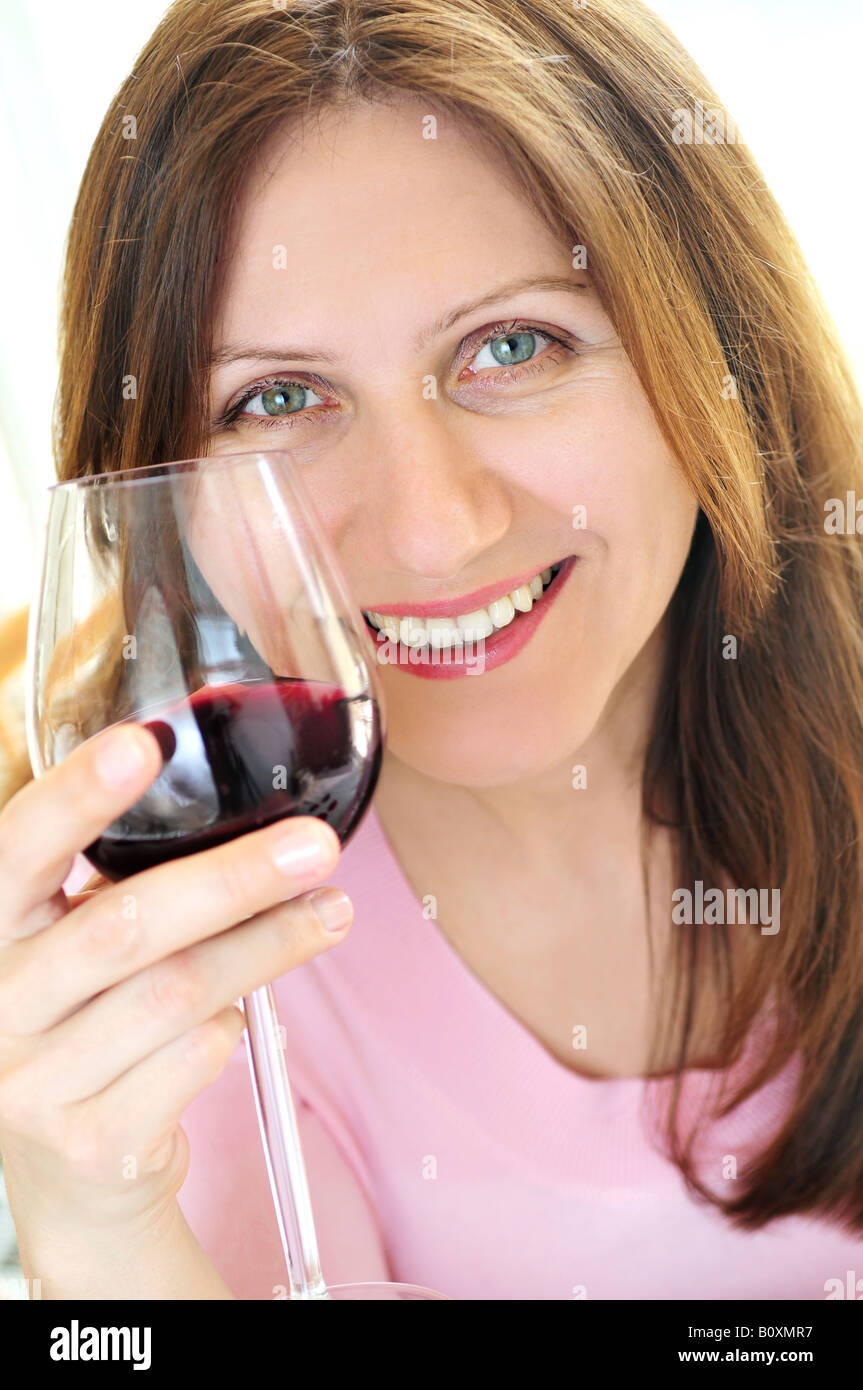 Smiling mature woman holding a glass of red wine Stock Photo - Alamy