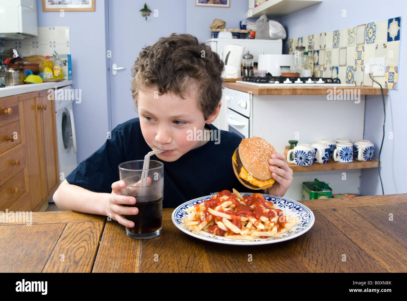 Boy eating junk food at home, UK Stock Photo