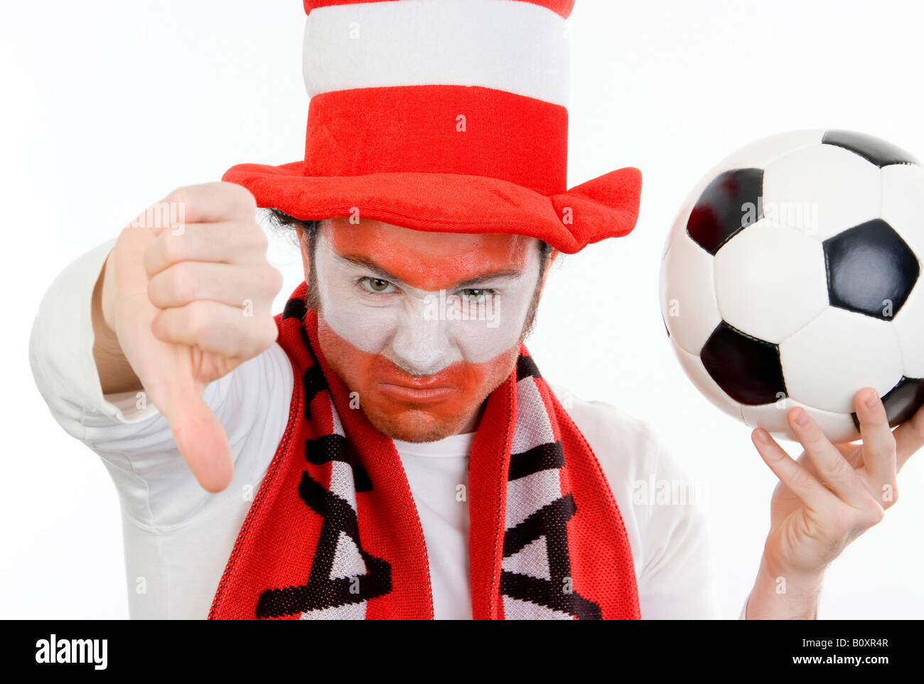 pessimistic Austrian soccer fan with football, making thumb down Stock Photo