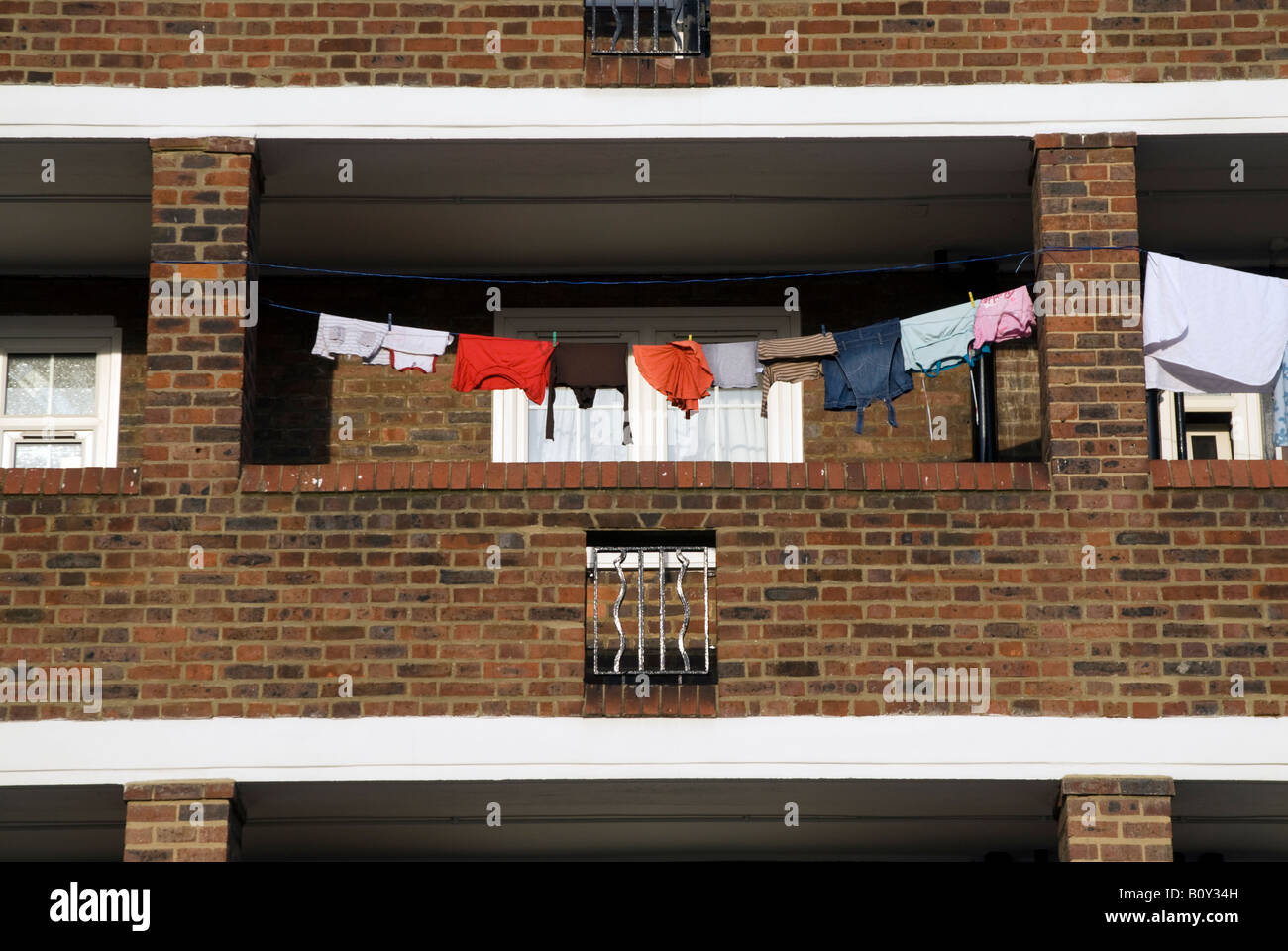 Clothes hanging out to dry on washing line in council estate tower block, London, England, UK Stock Photo