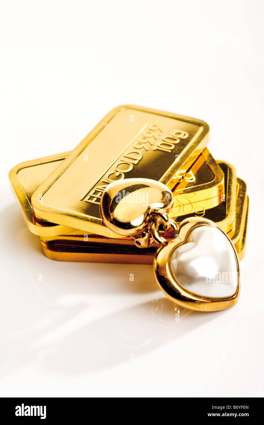 Gold bars and heart-shaped pedant Stock Photo