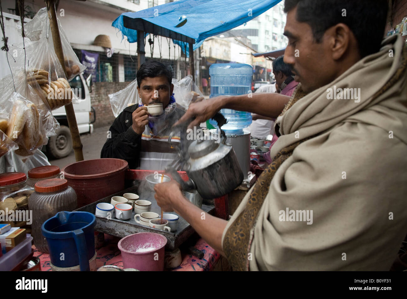 Customers drinking tea from a street vendor in Dhaka Bangladesh Stock