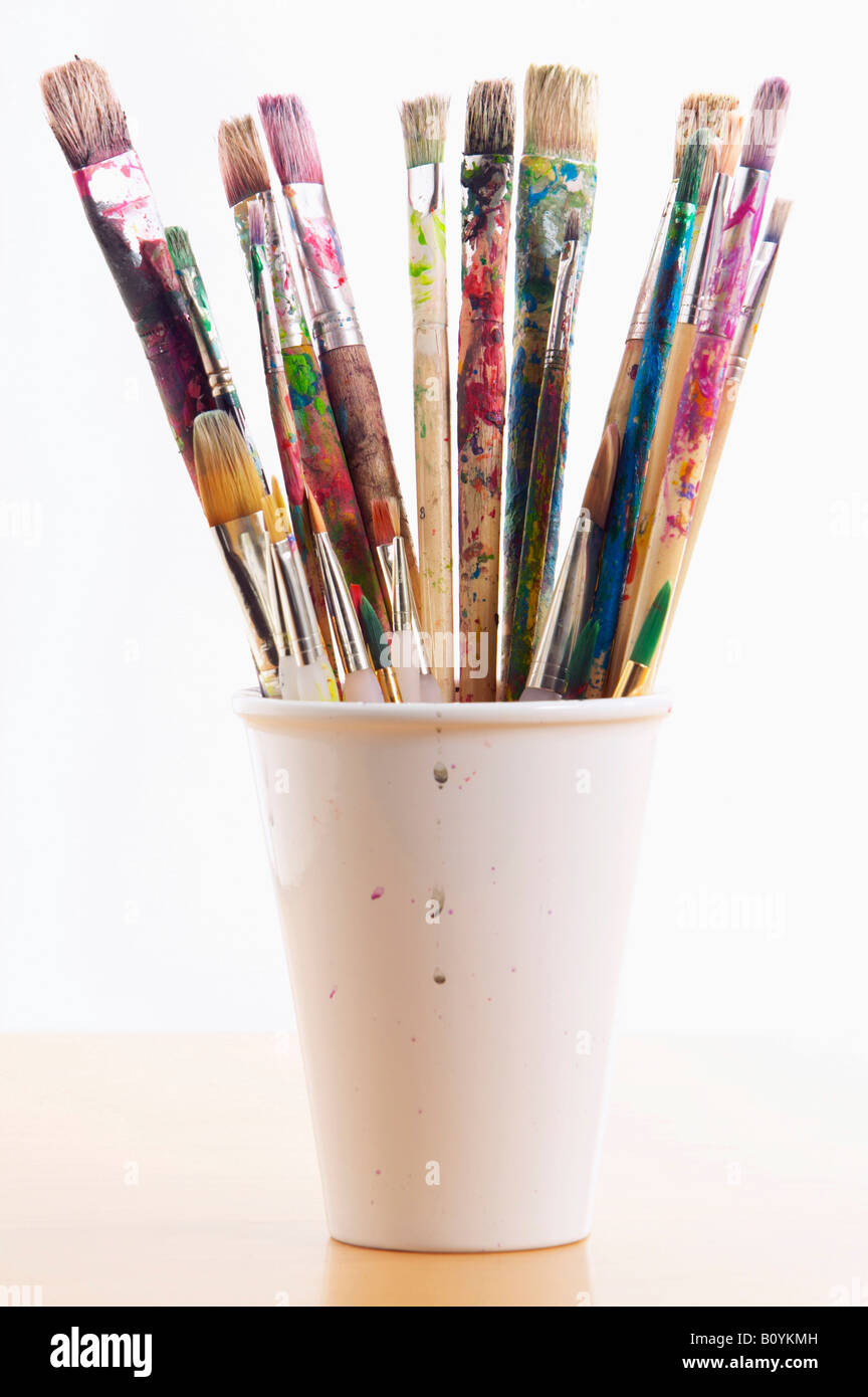 Artist's used paintbrushes in plastic cup Stock Photo Alamy