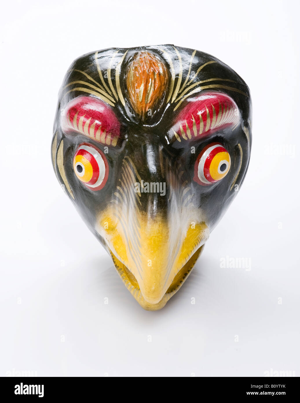 black papermache festival dance Peruvian mask of a bird with a yellow beak and red and yellow