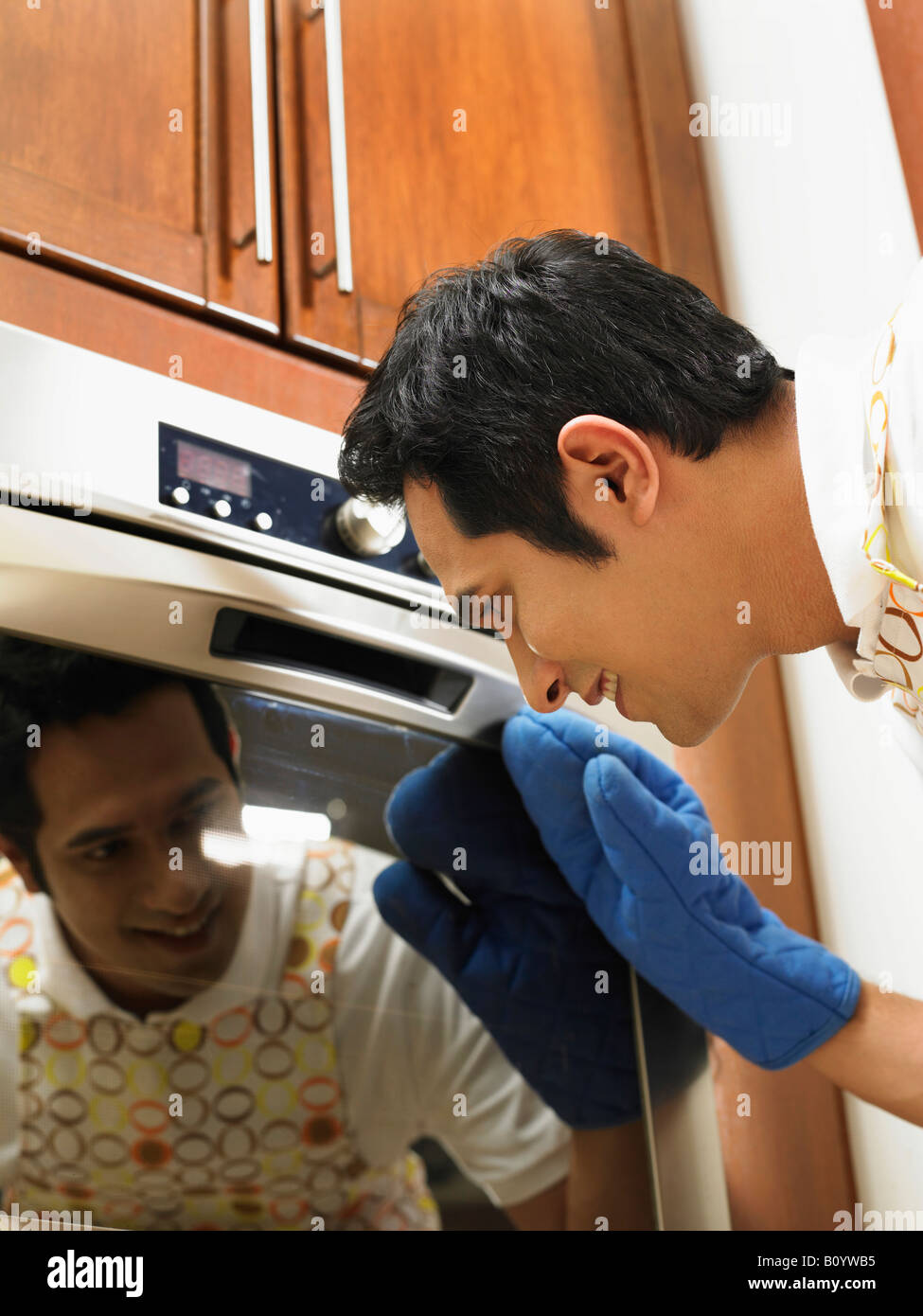 man looking into oven while baking Stock Photo Alamy
