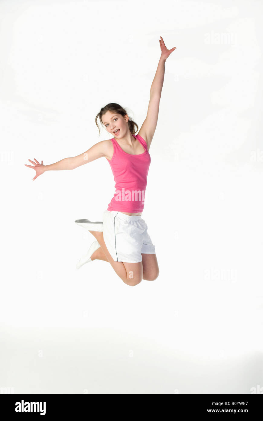 Brunette girl (13-14) in sportswear, jumping, portrait Stock Photo