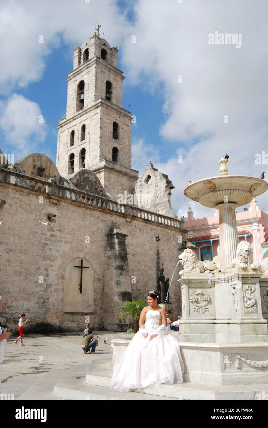 A bride poses by a fountain in the Plaza de San Francisco de Asis in Havana Vieja Stock Photo