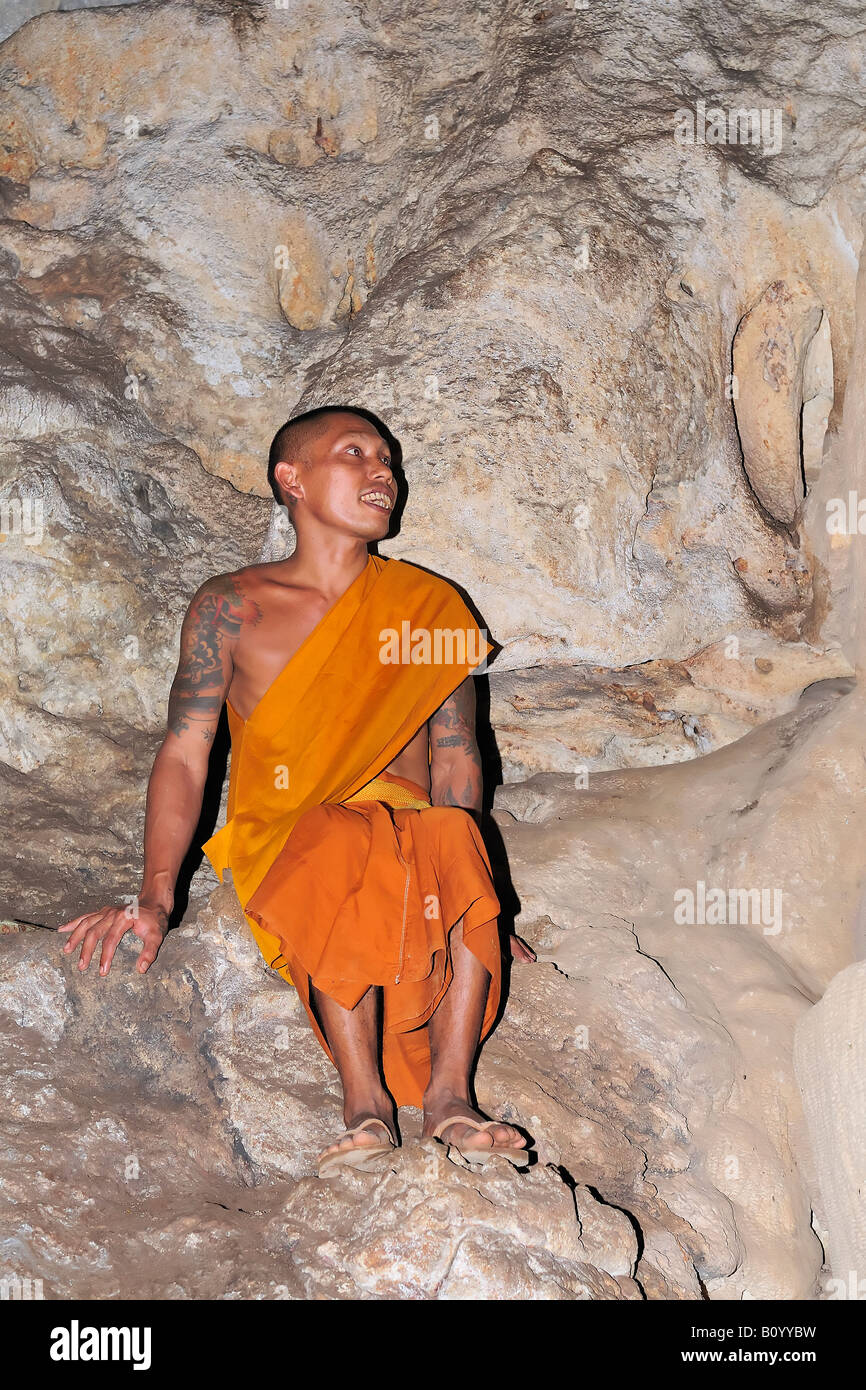 Buddhist monk with tattoos in a cave, Kanchanaburi province, Thailand. Stock Photo
