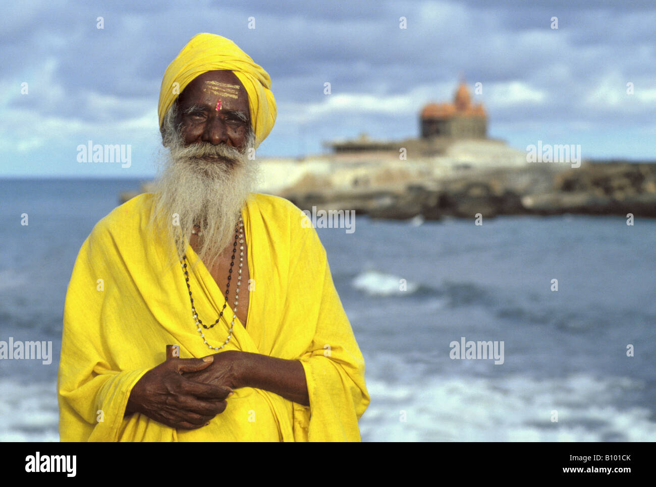 Portrait of a holy man in Kerala, Kanyakumari at the south point of India with behind him the Gandhi memorial Stock Photo