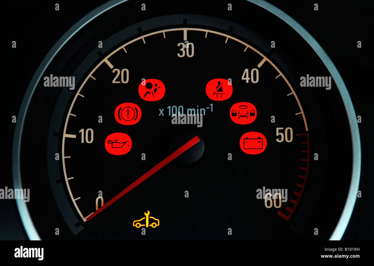 A BRITISH CAR DASHBOARD REV COUNTER DIAL WITH VARIOUS RED WARNING SYMBOLS LIGHTS SERVICING FUEL ENGINE SERVICE COSTS ETC,UK. Stock Photo