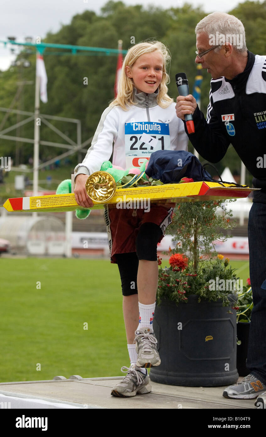 Price winner 10 year old girl Marta Qvirist with trophies after the running race on 1300m long track Stock Photo