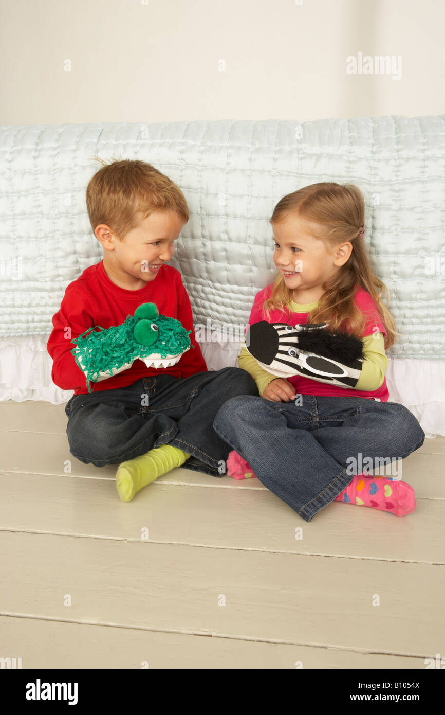 a boy and a girl play with home made hand puppets Stock Photo