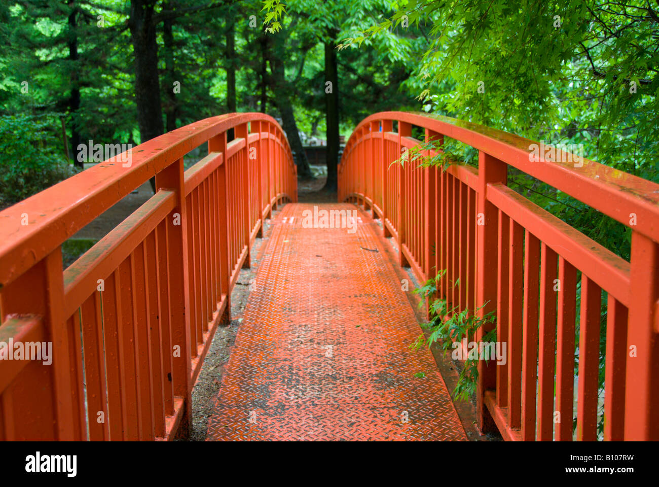 A vermilion bridge crosses the Togawa To River at the Harumiya Shrine Suwa Taisha, Shimosuwa, Nagano, Japan Stock Photo