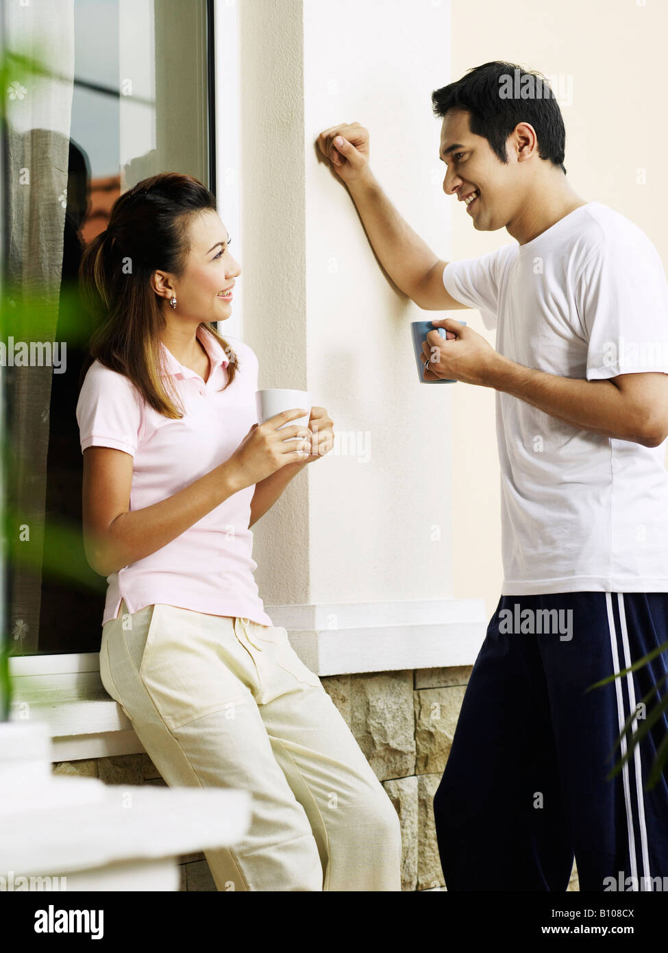 Asian wife with husband in backyard Stock Photo