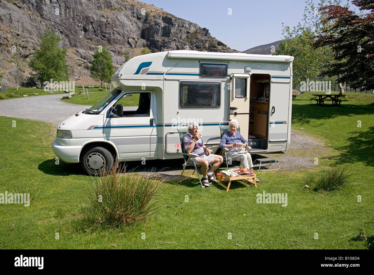 Senior couple outside Calypso motor caravan campervan picnic area Elan Valley Mid Wales UK Stock Photo