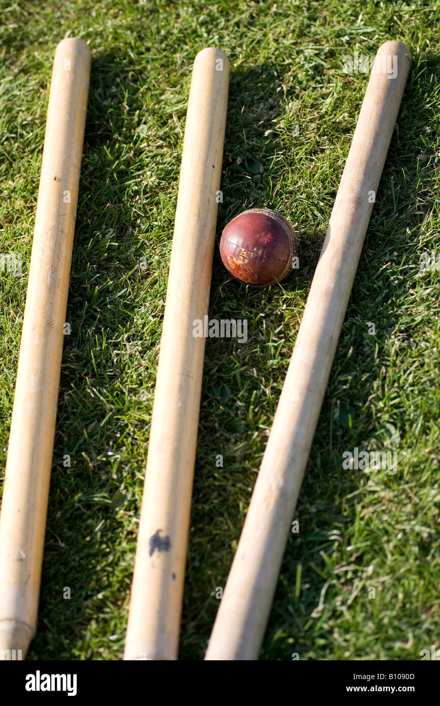 Cricket stumps and ball lie on the ground Stock Photo