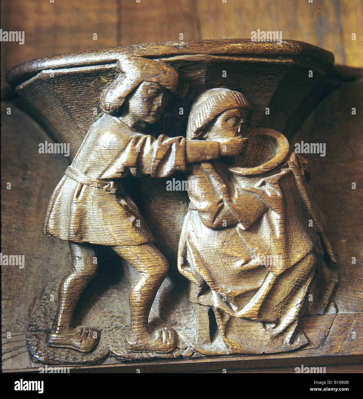 Misericord from Beauvois 15th cent Man feeds wife France Stock Photo