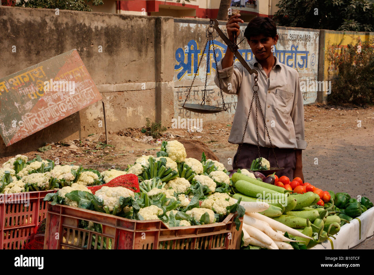 A vendor is weighing and selling vegetables on his stall at the Stock