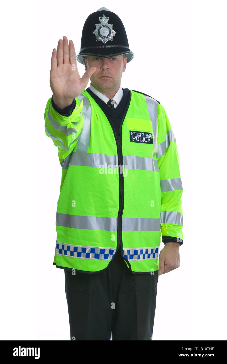 Metropolitan Police officer wearing a yellow reflective jacket indicating for you to Stop Stock Photo