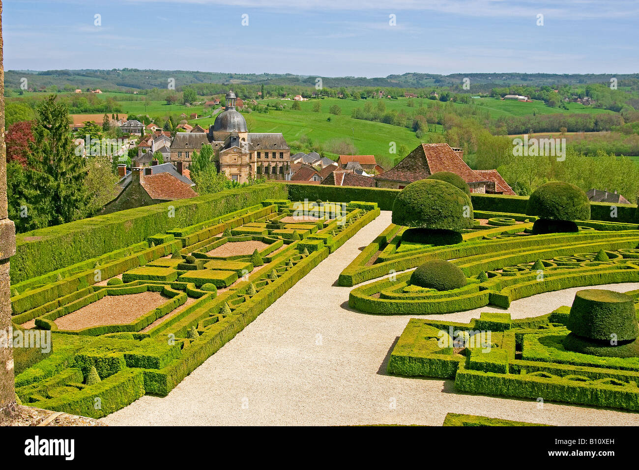 View over the formal gardens at Chateau de Hautefort over the town below in the Dordogne region of France Stock Photo