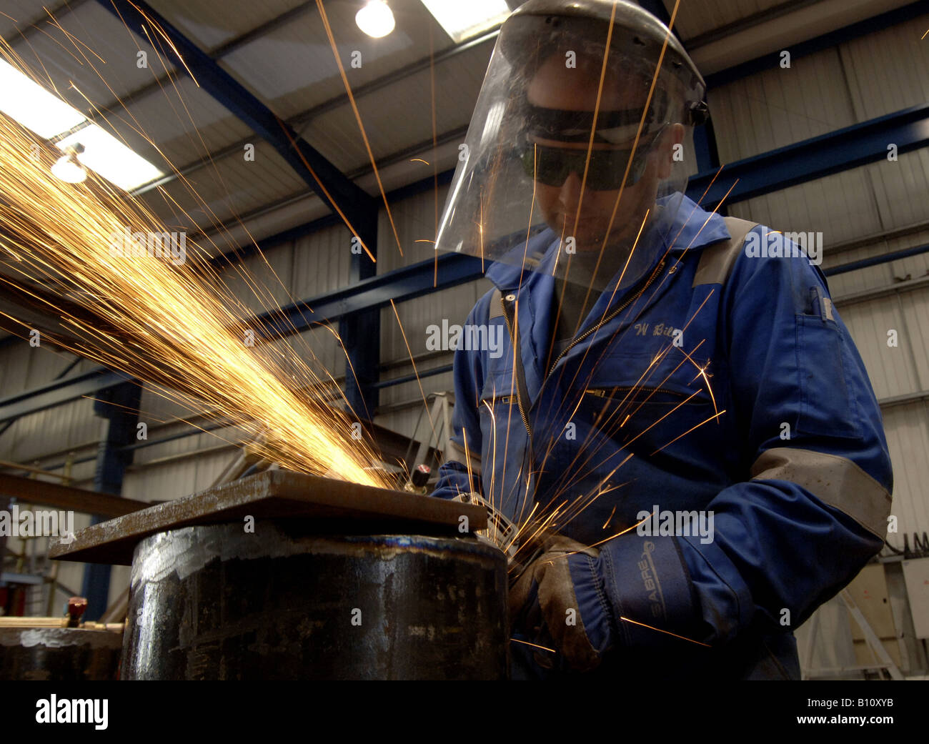 A Metalworker grinding in a fabrication yard Stock Photo - Alamy