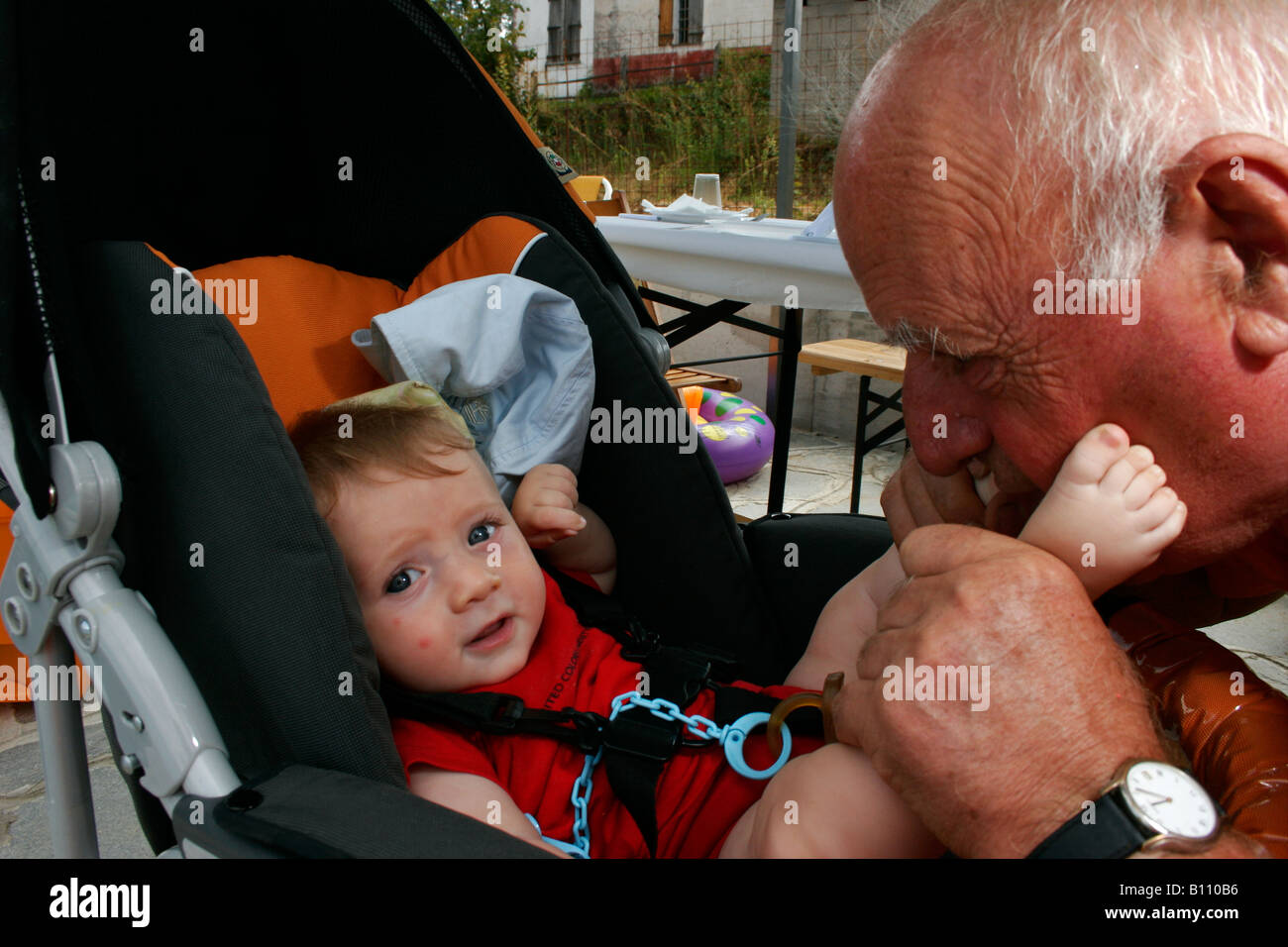 A baby and his grandfather playing in the summer Stock Photo
