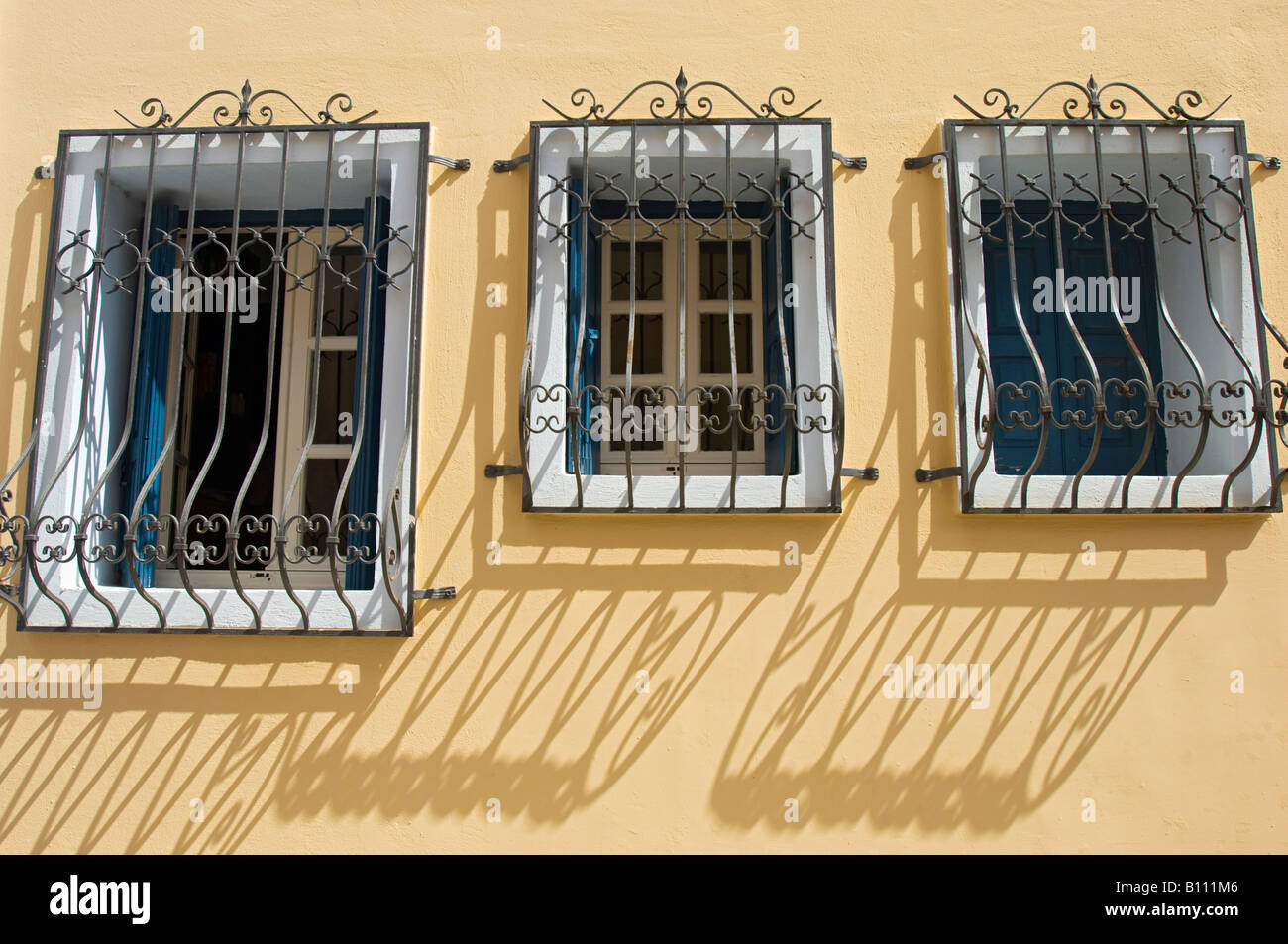 Interesting shadows of window railings against a bright yellow wall ...