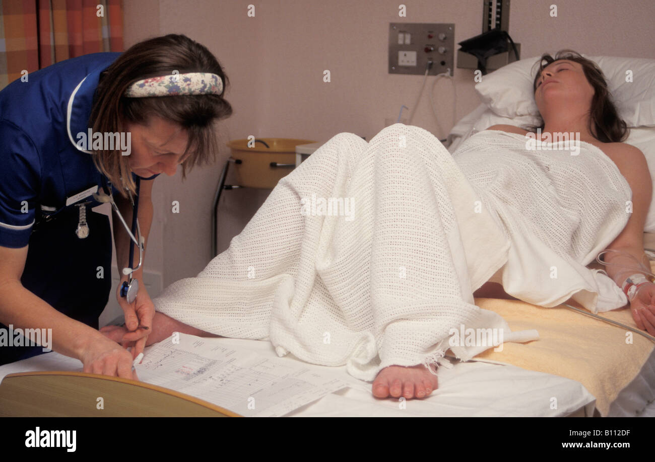 midwife monitoring young woman in labour in hospital Stock Photo