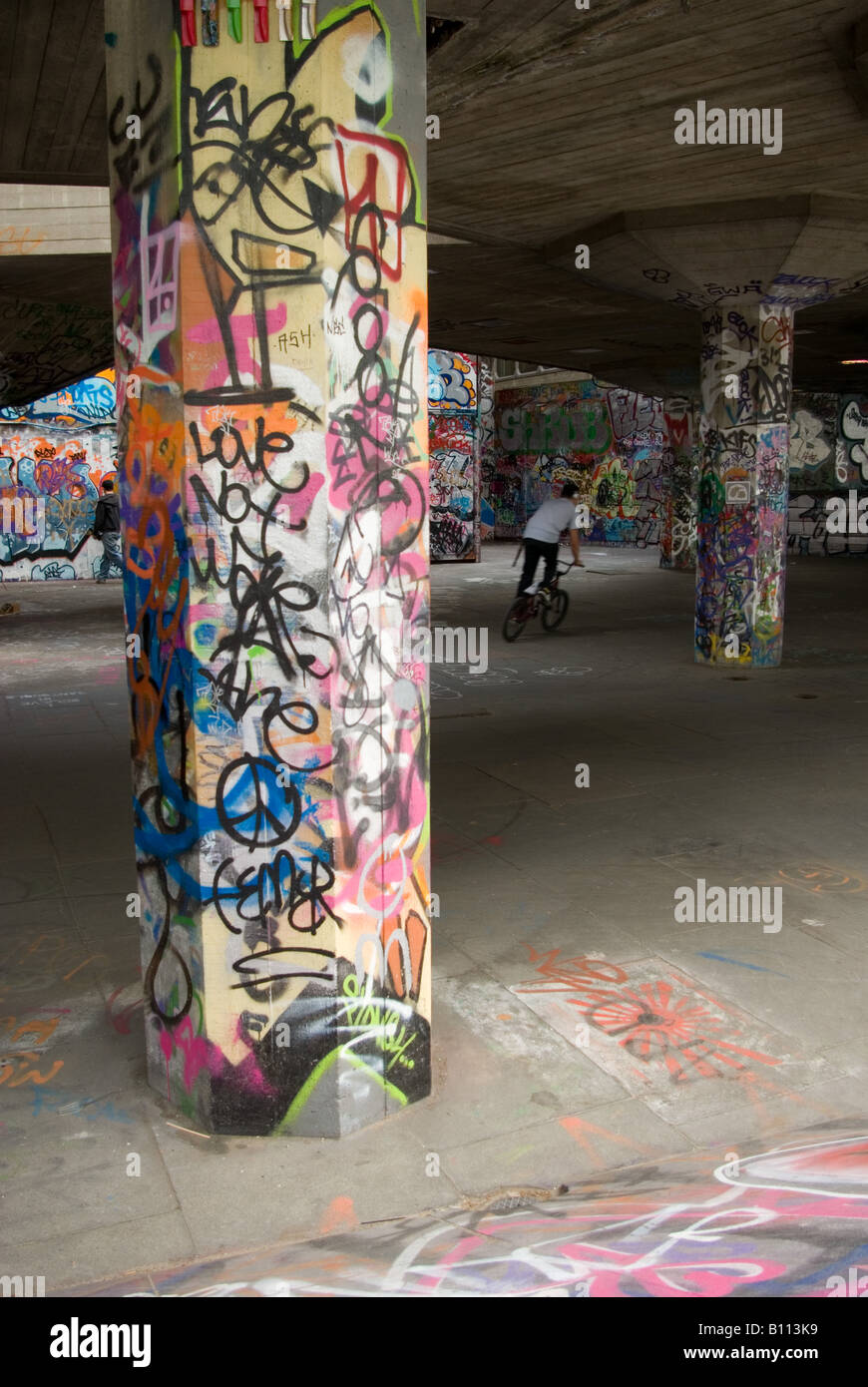 South Bank, Bike rider and graffiti artist Stock Photo