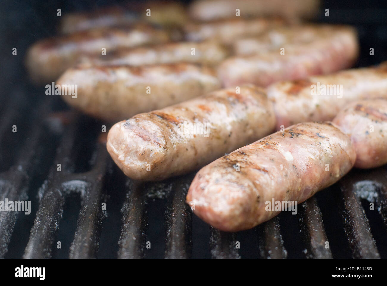 Sweet Italian sausages cooking on an outdoor grill, closeup Stock Photo