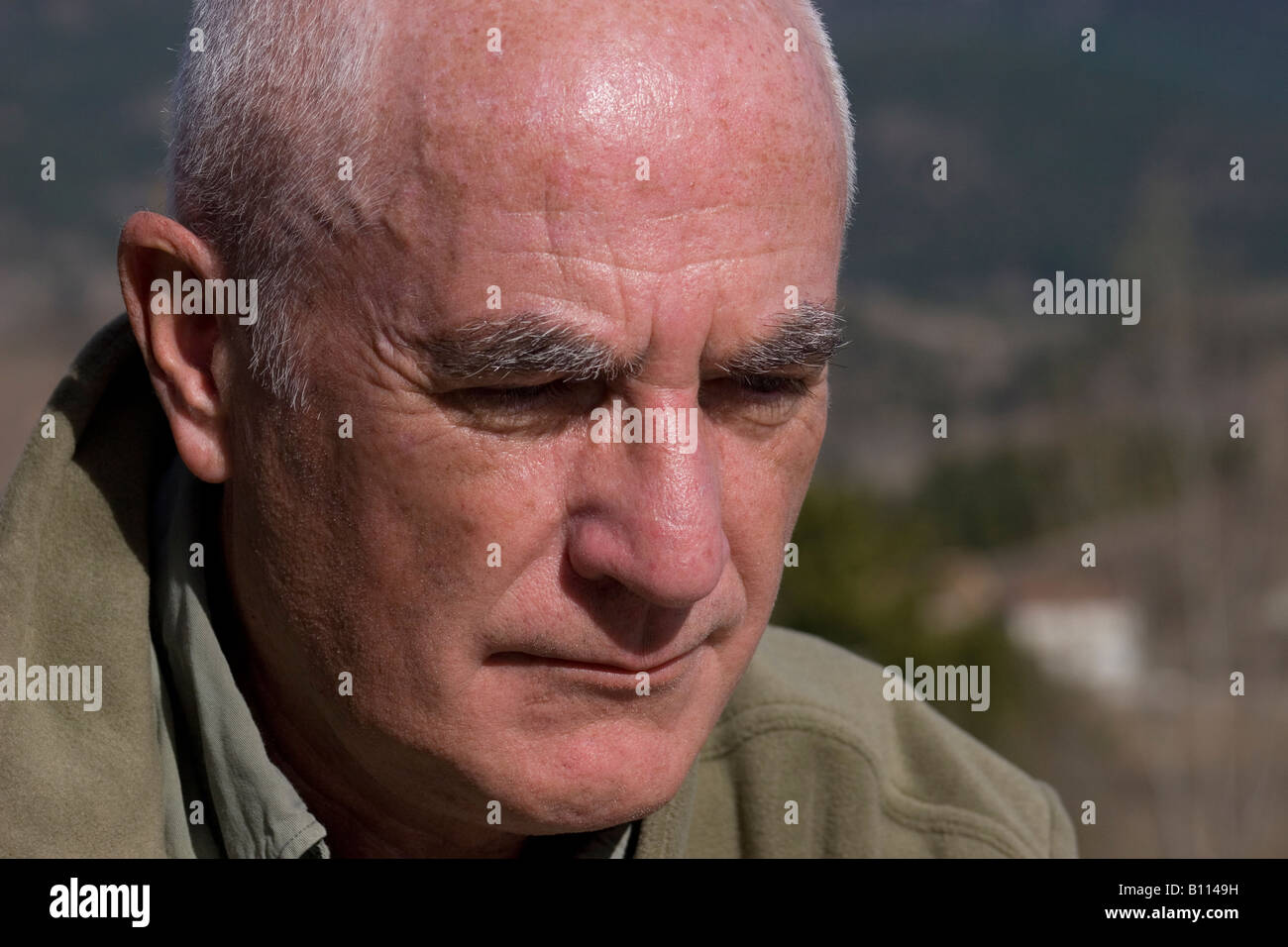 mature gentleman sitting outdoors looking dejected Stock Photo
