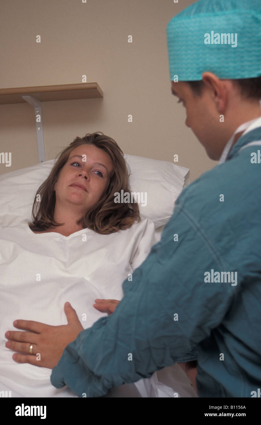 surgeon anaethetist talking to teenage young woman in labour in hospital Stock Photo