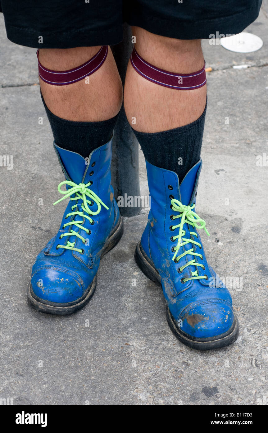 A blue pair of bright blue Doc Martin boots with green laces being
