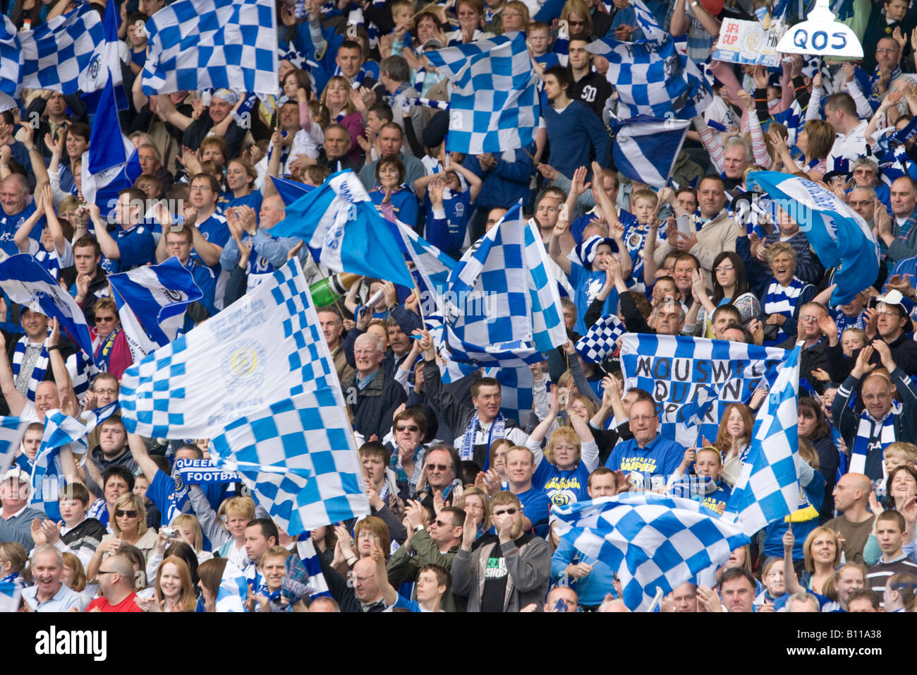 Crowd at football game waving flags cheering supporting thier team to victory Scottish Cup Final Queen of the South v Rangers UK Stock Photo