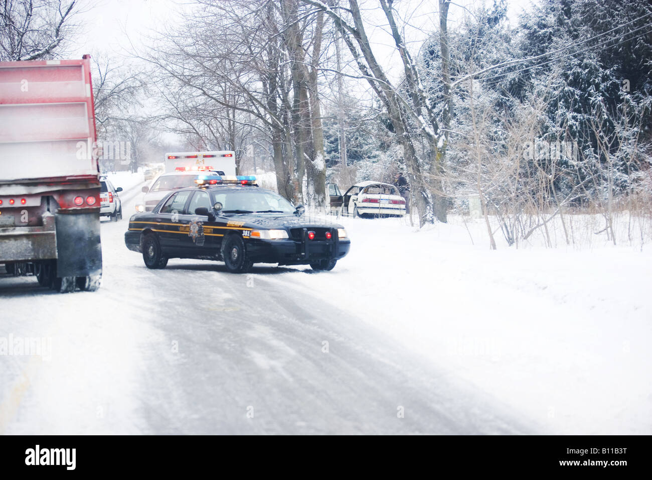 Police and emergency vehicles at scene of accident on snowy road Stock ...