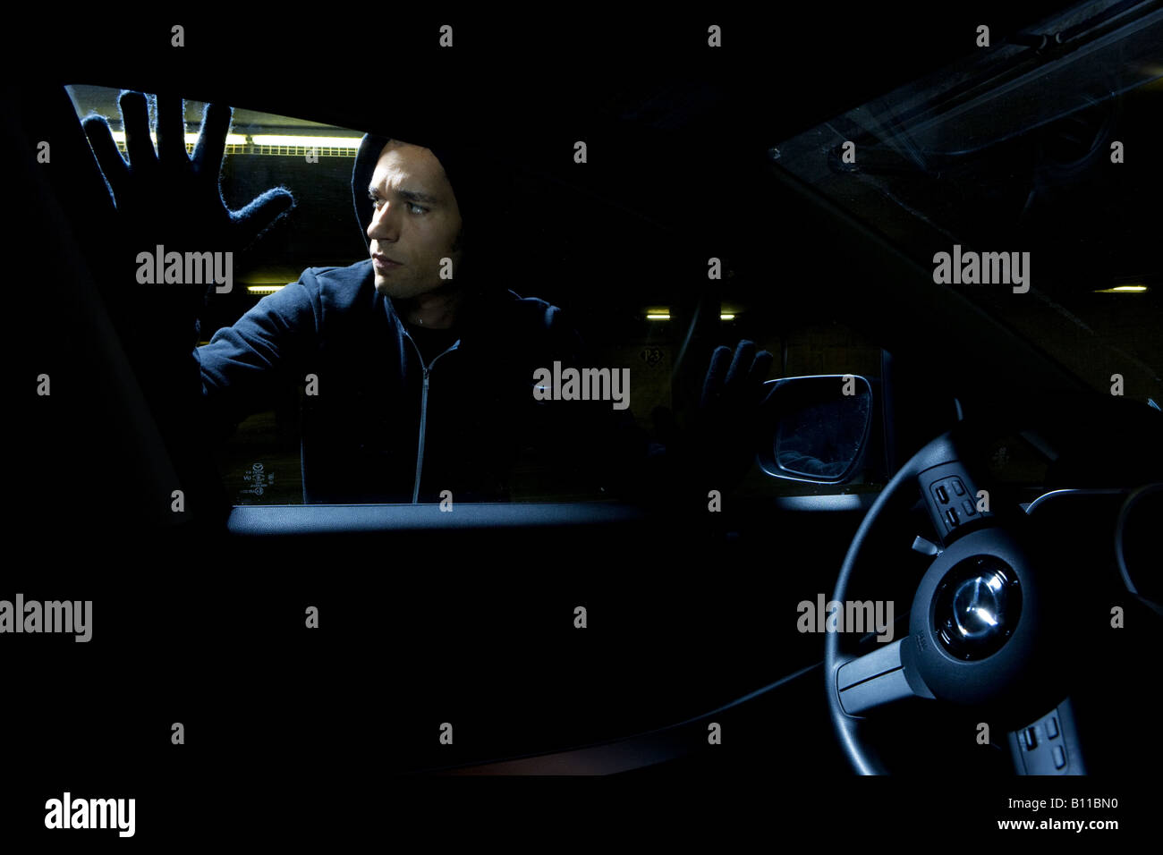 Thief looking to break into car window Stock Photo Alamy