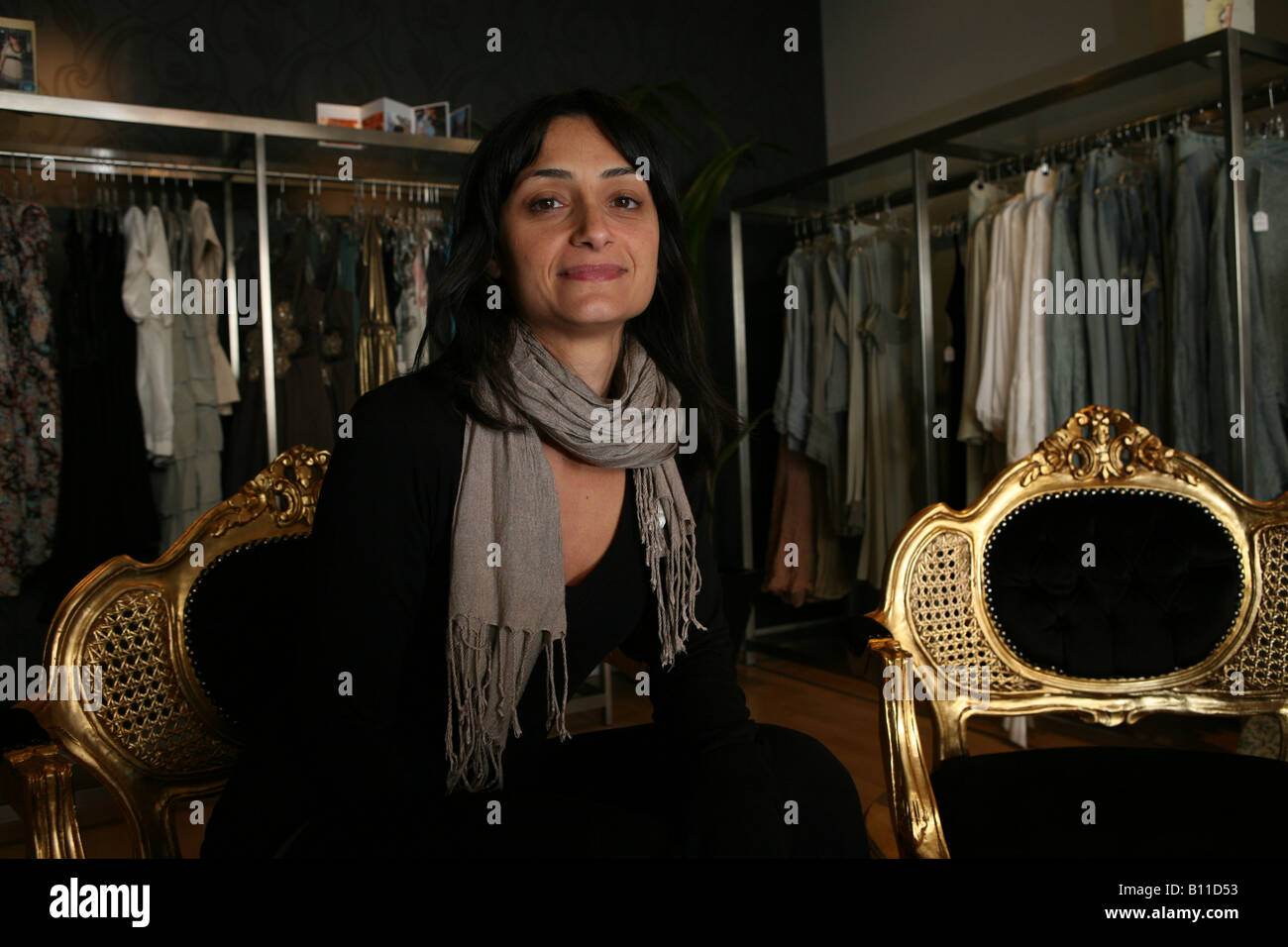 a portrait of a beutiful middle aged woman in a stylish clothing shop with her reflection in a mirror Stock Photo