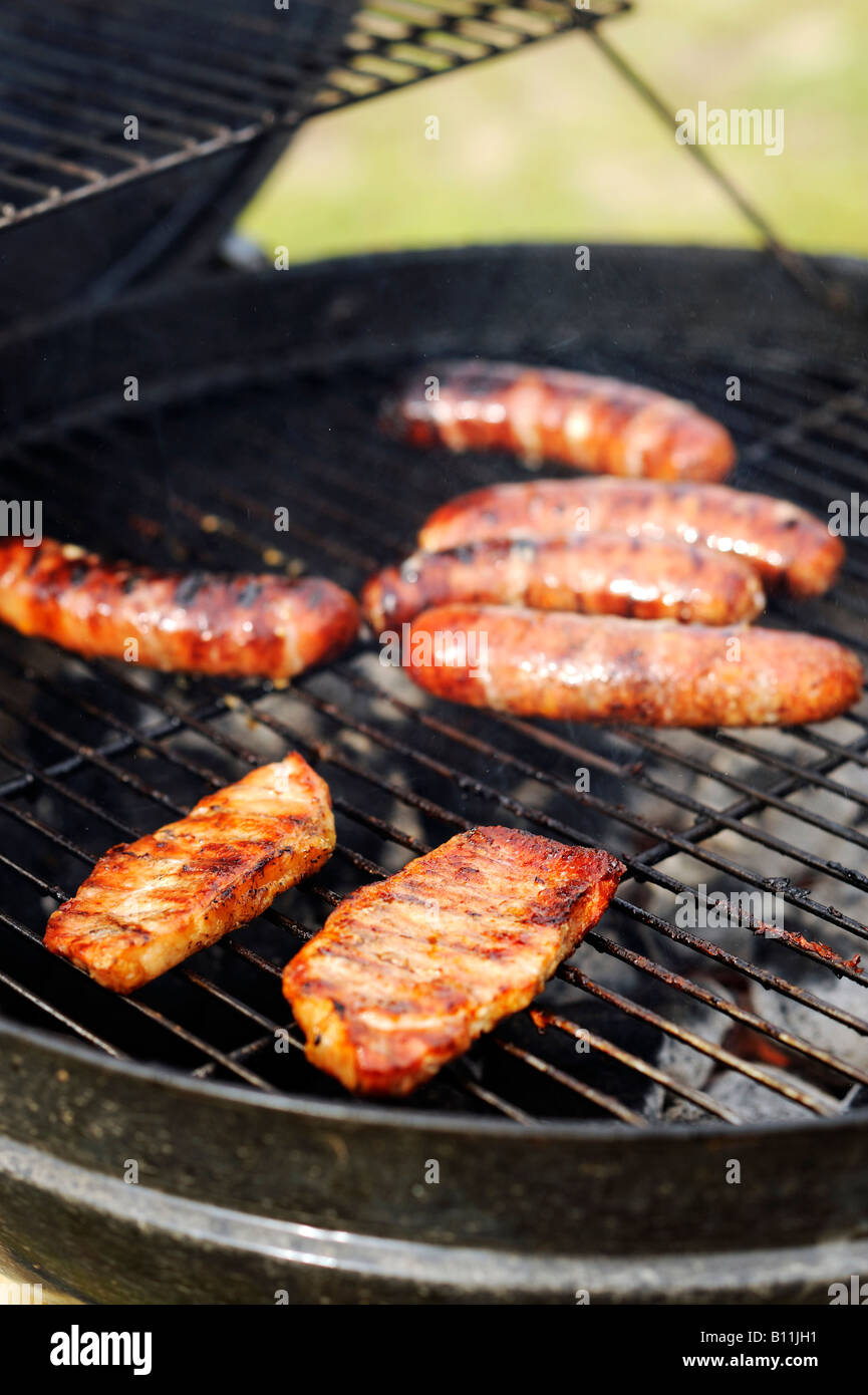 Grilling bratwursts and pork on a charcoal grill Stock Photo Alamy