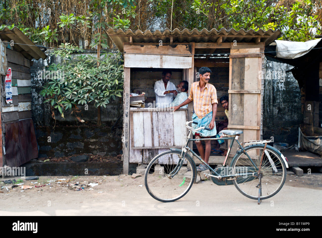 INDIA KERALA KOCHI Tiny barber shop in a shack on a dirt street in the