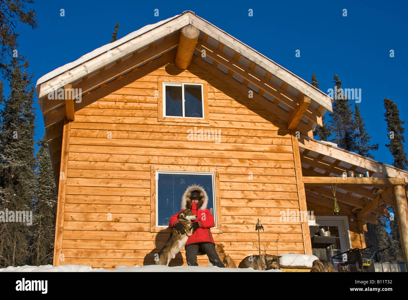 Dogsled musher Julie Estey with one of her racing dogs by her cabin in