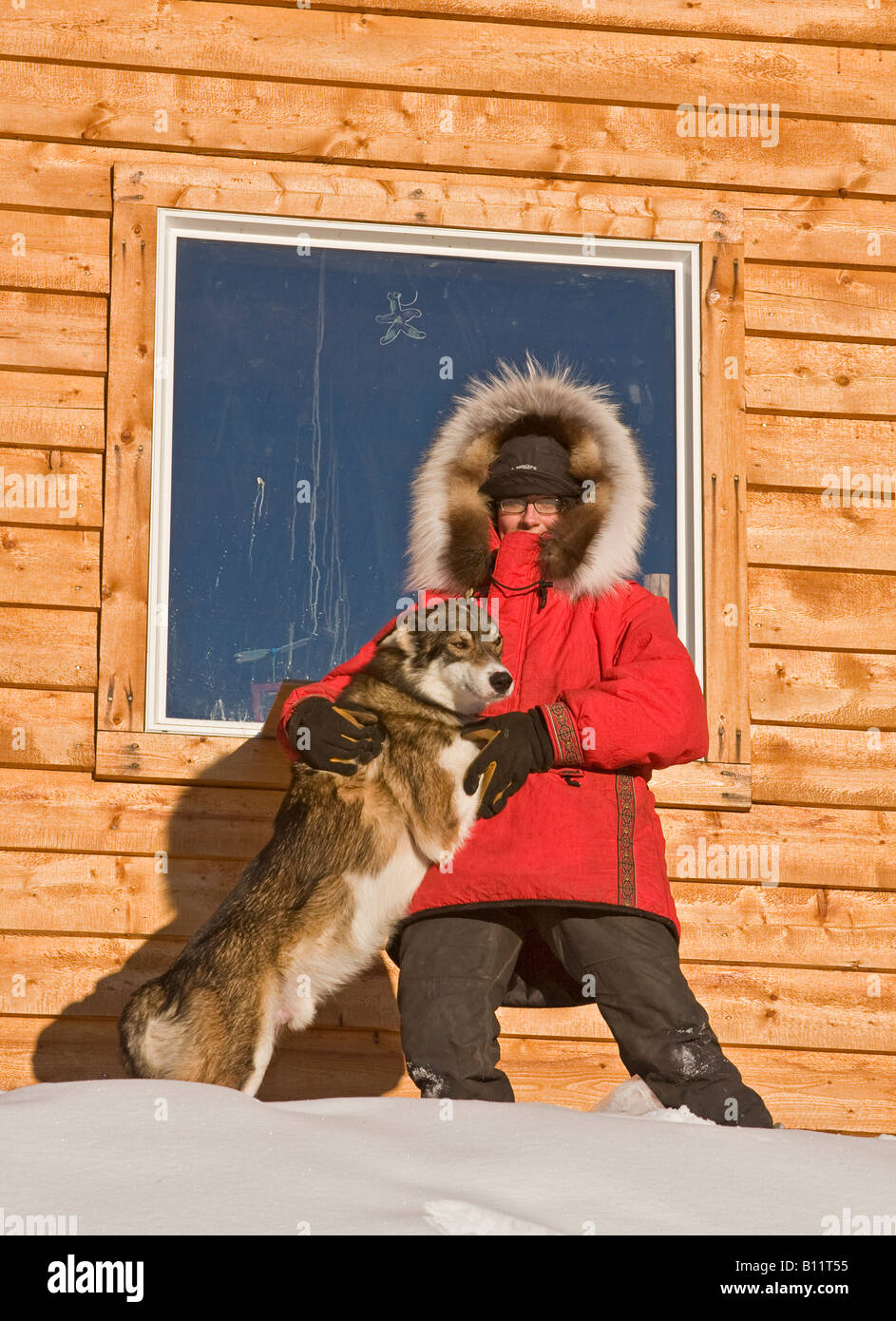 Dogsled musher Julie Estey with one of her racing dogs by her cabin in