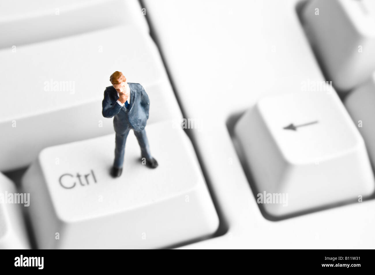 Businessman figurine standing on a computer keyboard Stock Photo