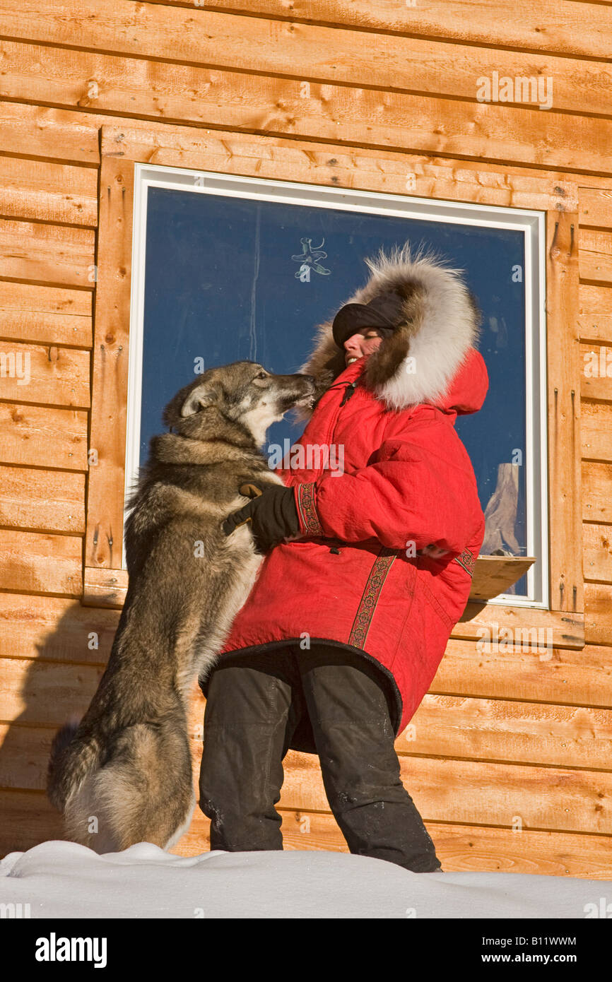 Dogsled musher Julie Estey with one of her racing dogs and dressed in