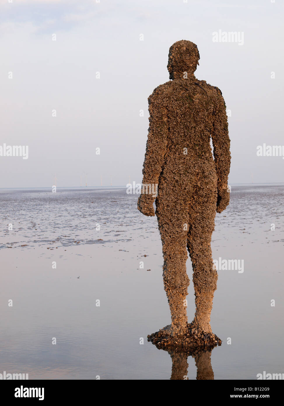 ANTONY GORMLEY SCULPTURED FIGURE ON BEACH AT CROSBY, LIVERPOOL