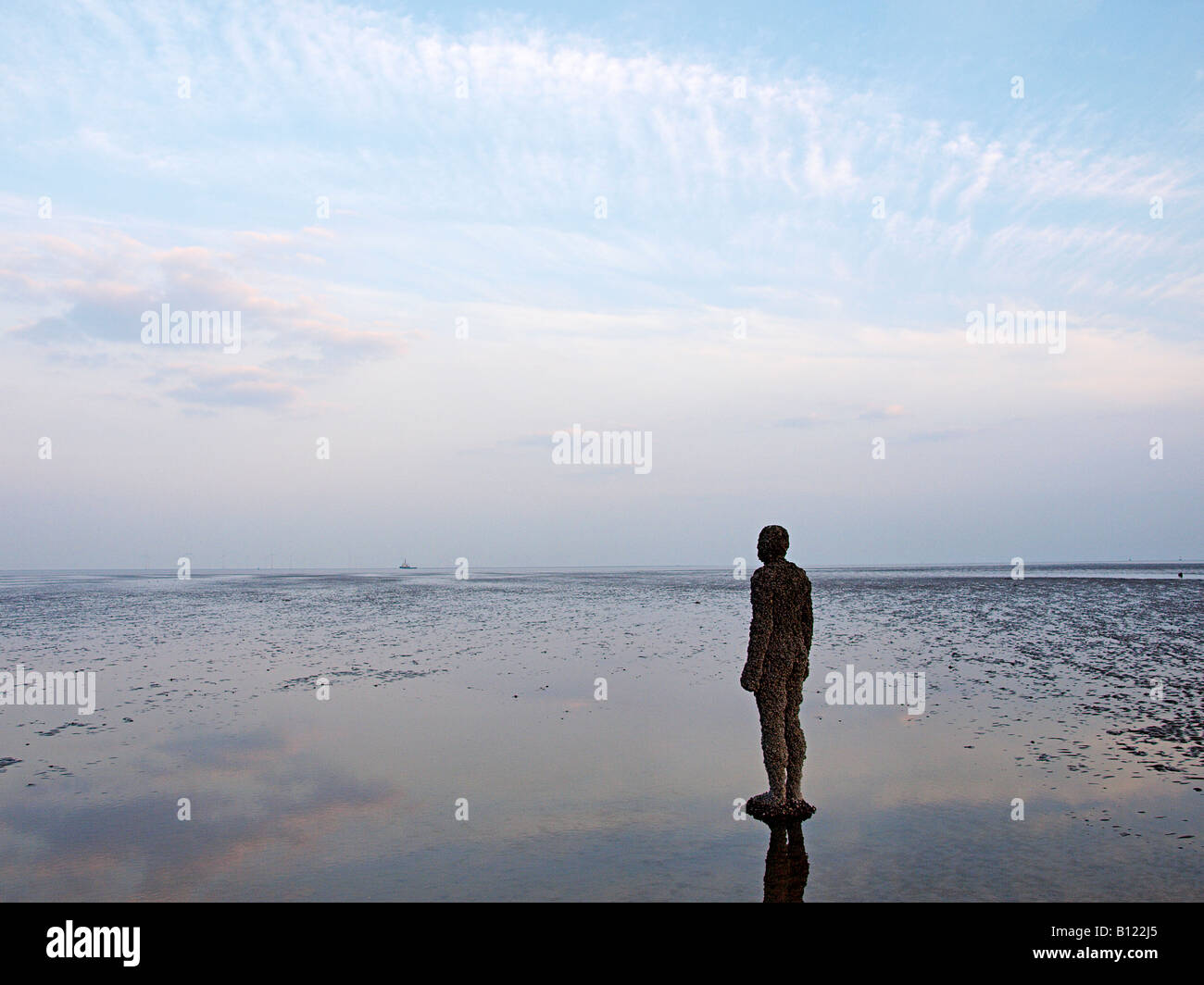 ANTONY GORMLEY SCULPTURED FIGURE ON BEACH AT CROSBY, LIVERPOOL