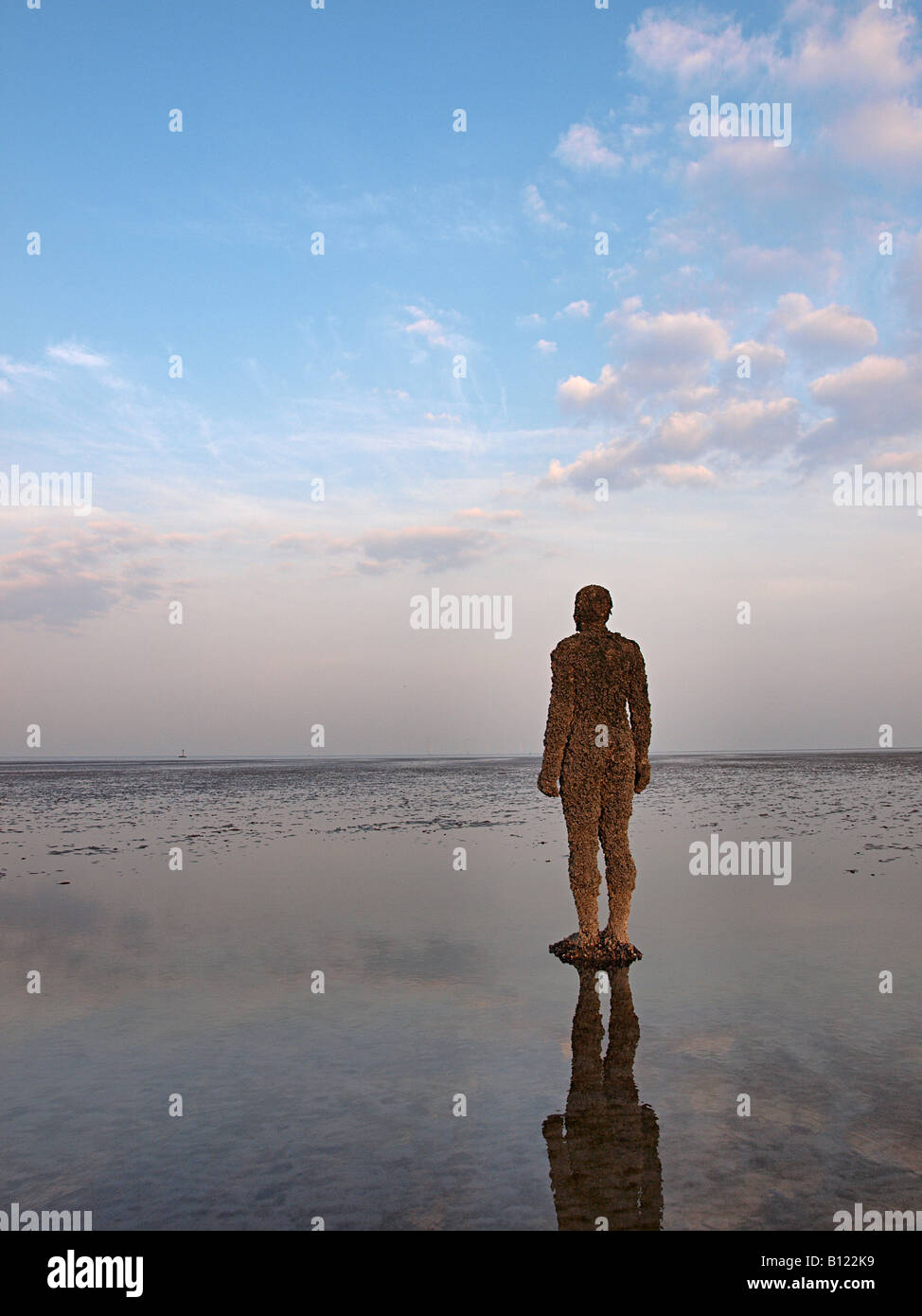 ANTONY GORMLEY SCULPTURED FIGURE ON BEACH AT CROSBY, LIVERPOOL