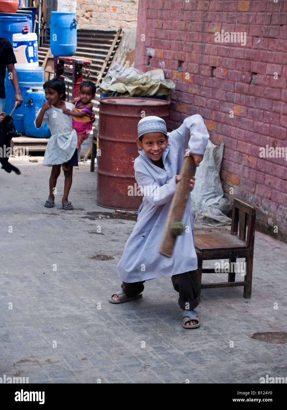 boy batting during street cricket game in Kolkata India Stock Photo