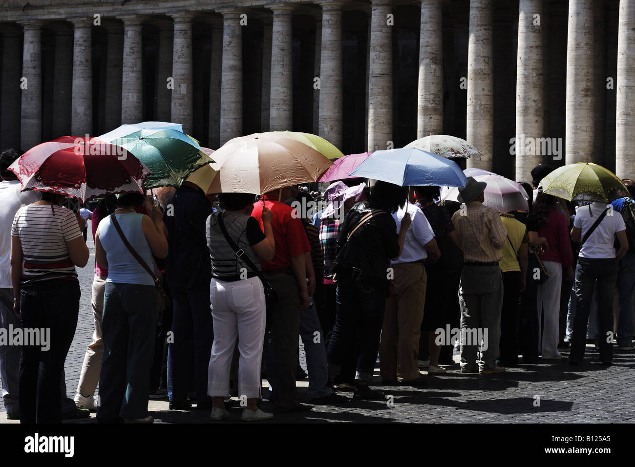 Tourists with an umbrella making a queue to get into the Vatican in St. Peter's square Stock