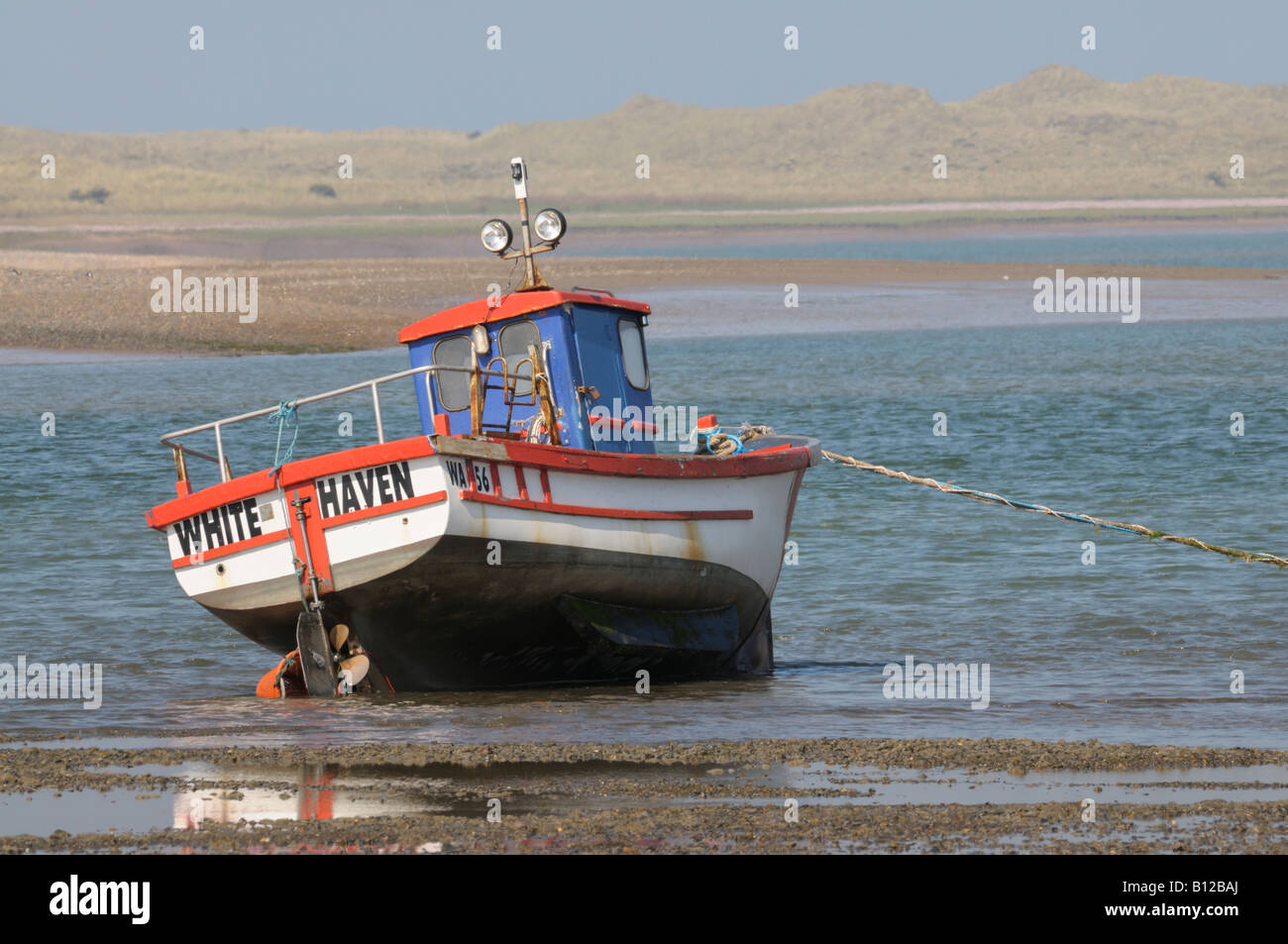 Fishing boat moored at low tide in the River Esk estuary Stock Photo